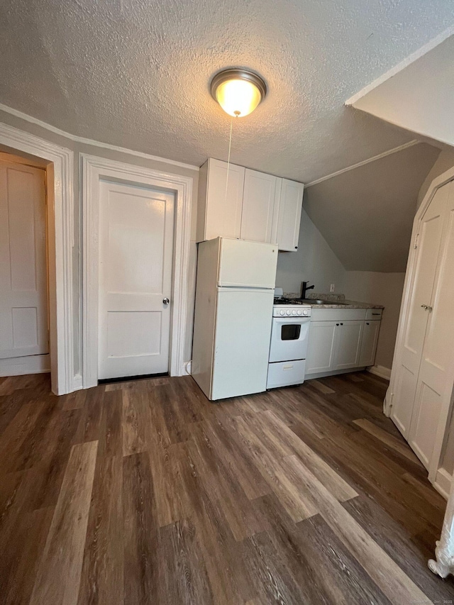 kitchen featuring dark wood-type flooring, vaulted ceiling, white cabinets, white appliances, and a textured ceiling