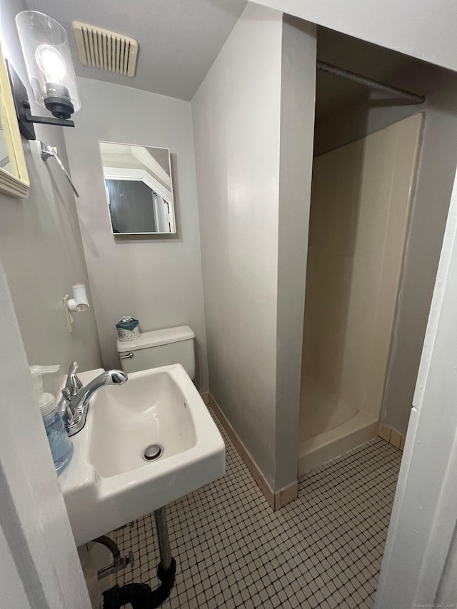 full bathroom featuring tile patterned flooring, visible vents, baseboards, a stall shower, and a sink