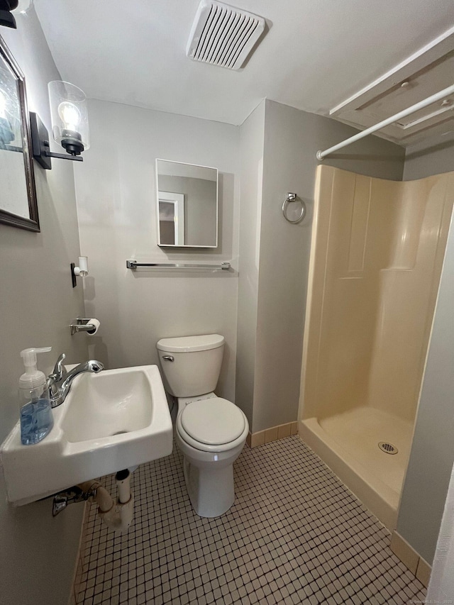 full bath with visible vents, a stall shower, toilet, and a sink