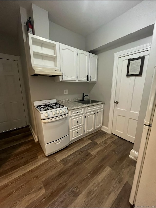 kitchen with white appliances, a sink, dark wood-type flooring, white cabinets, and under cabinet range hood