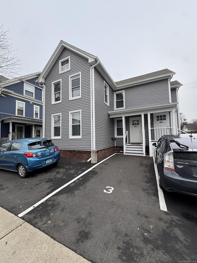 view of front of property with covered porch and uncovered parking