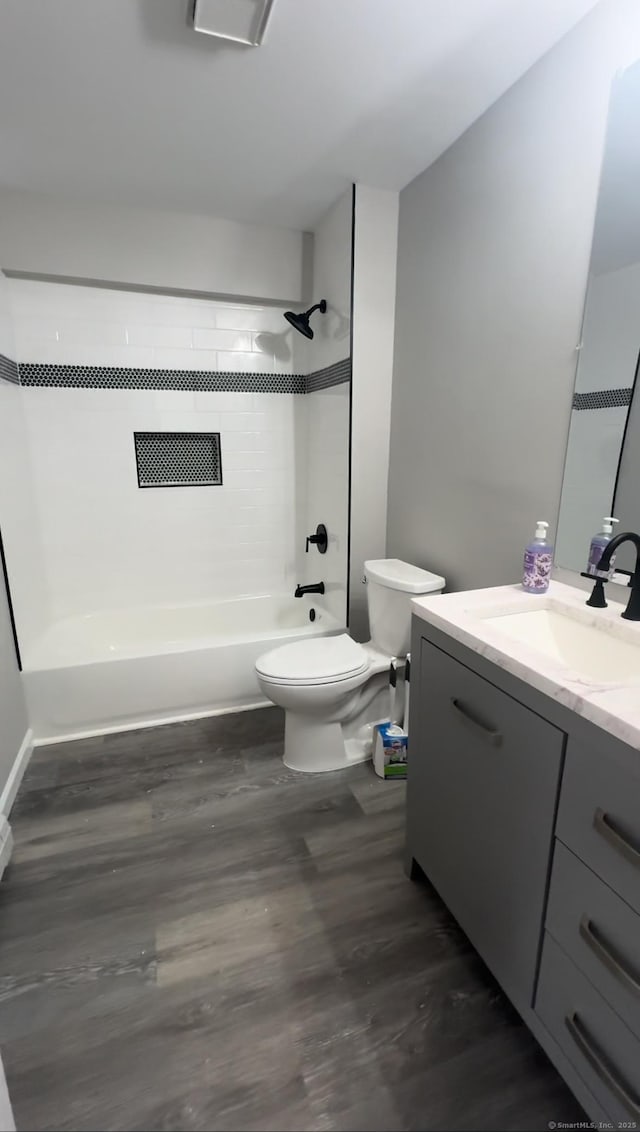 full bathroom featuring tub / shower combination, toilet, vanity, and wood finished floors