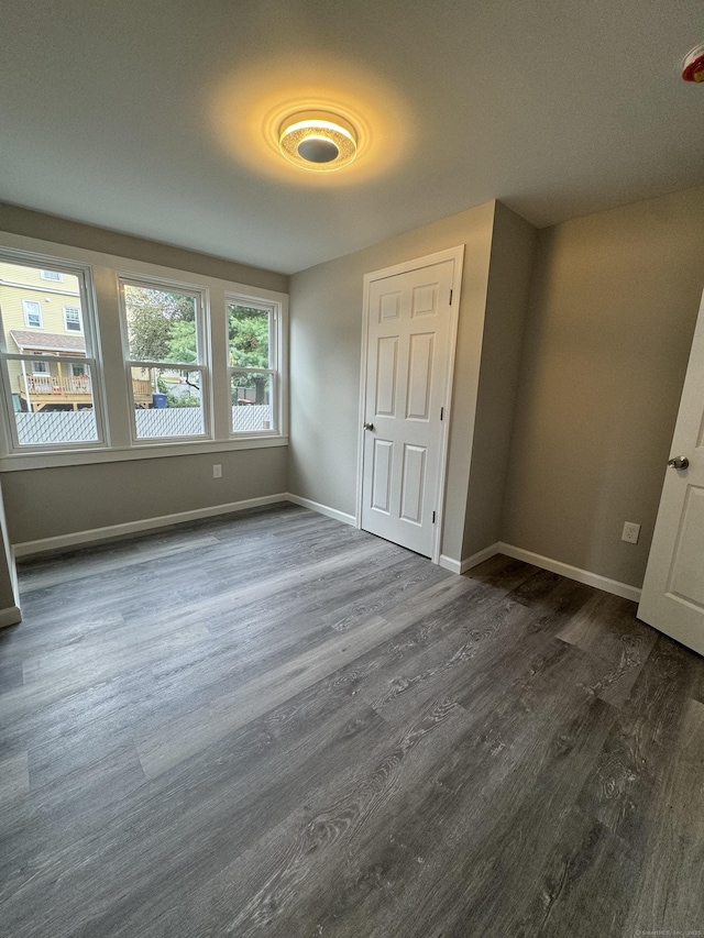 unfurnished bedroom featuring dark wood-type flooring and baseboards