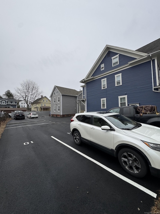 view of property exterior with a residential view and uncovered parking