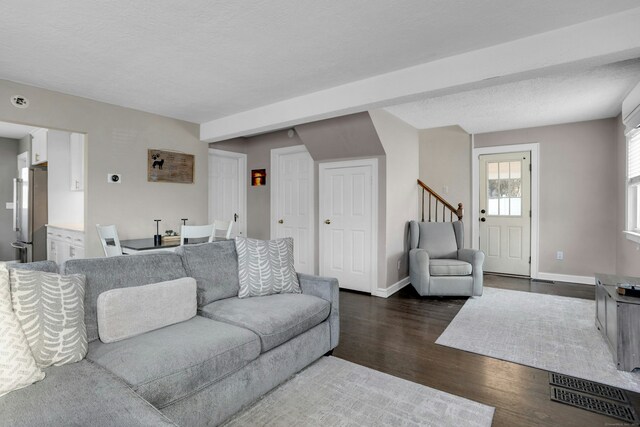 living room with dark hardwood / wood-style floors and a textured ceiling