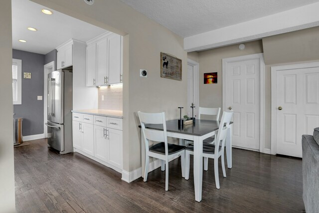 dining area with dark hardwood / wood-style floors and a textured ceiling