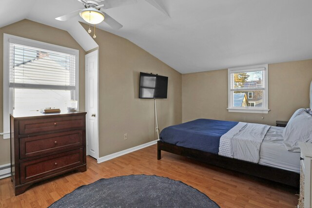 bedroom with vaulted ceiling, multiple windows, and light hardwood / wood-style flooring