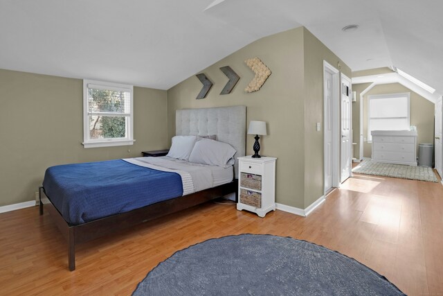 bedroom featuring lofted ceiling and light hardwood / wood-style floors