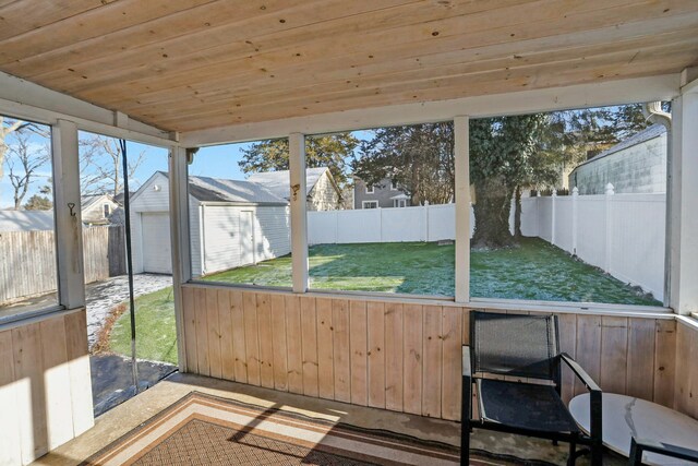 unfurnished sunroom with lofted ceiling, wood ceiling, and a healthy amount of sunlight