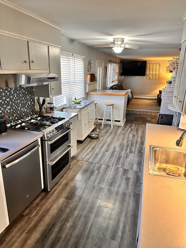 kitchen featuring ceiling fan, decorative backsplash, white cabinetry, dark wood-type flooring, and stainless steel appliances