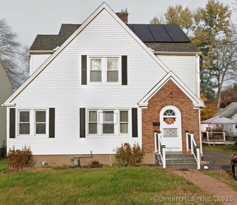 view of front property with a front lawn and solar panels