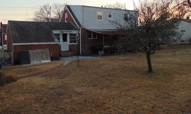 back house at dusk with a lawn