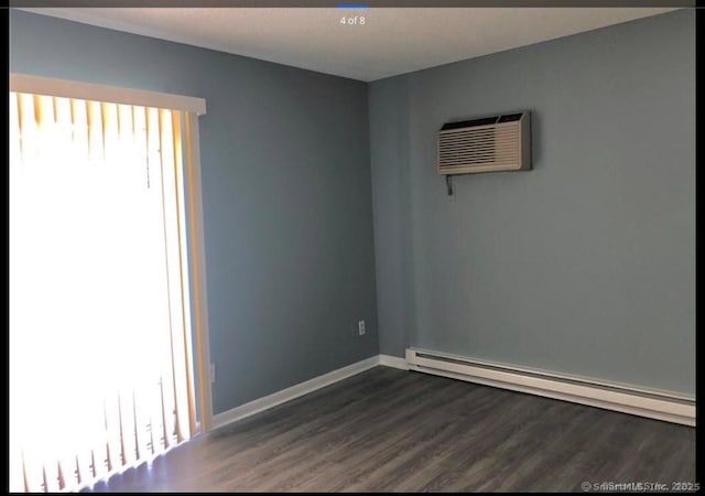 spare room with dark hardwood / wood-style floors, a baseboard radiator, and a wall mounted AC