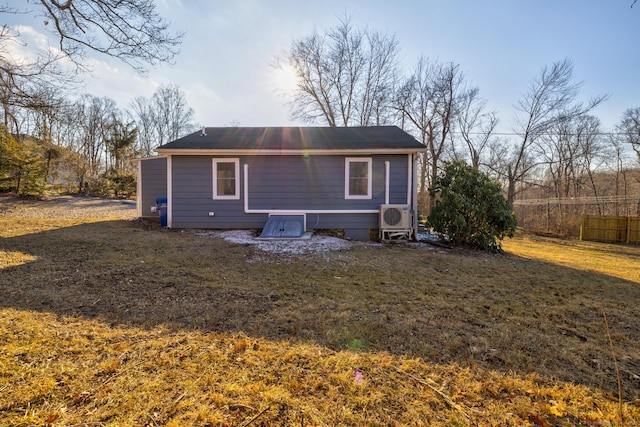 back of house with ac unit and a lawn