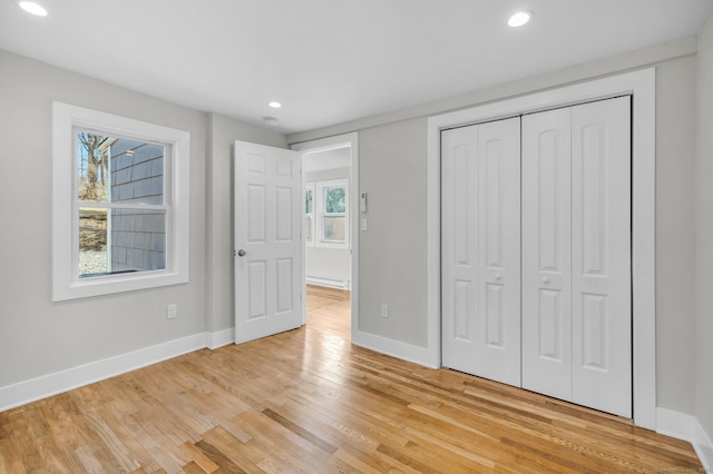 unfurnished bedroom with light hardwood / wood-style floors and a closet