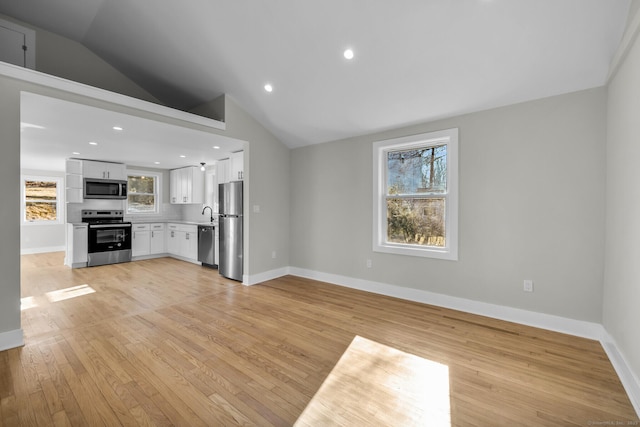 unfurnished living room with lofted ceiling and light hardwood / wood-style floors