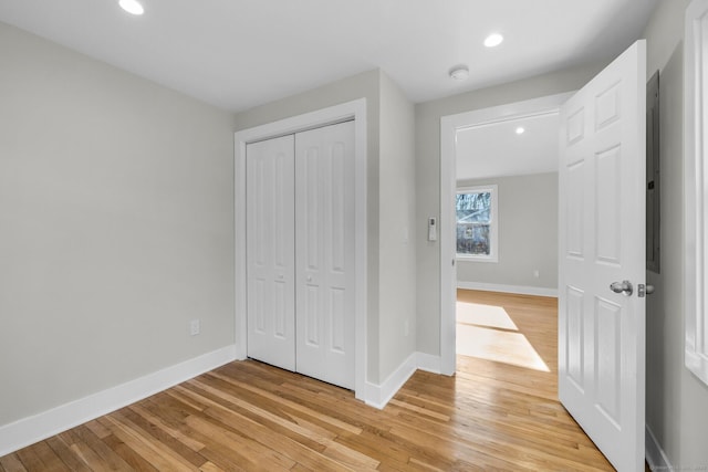 unfurnished bedroom featuring light wood-type flooring and a closet