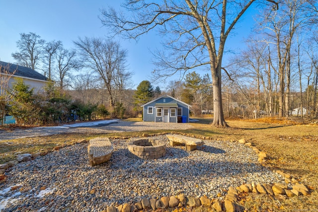 view of yard featuring an outbuilding and an outdoor fire pit