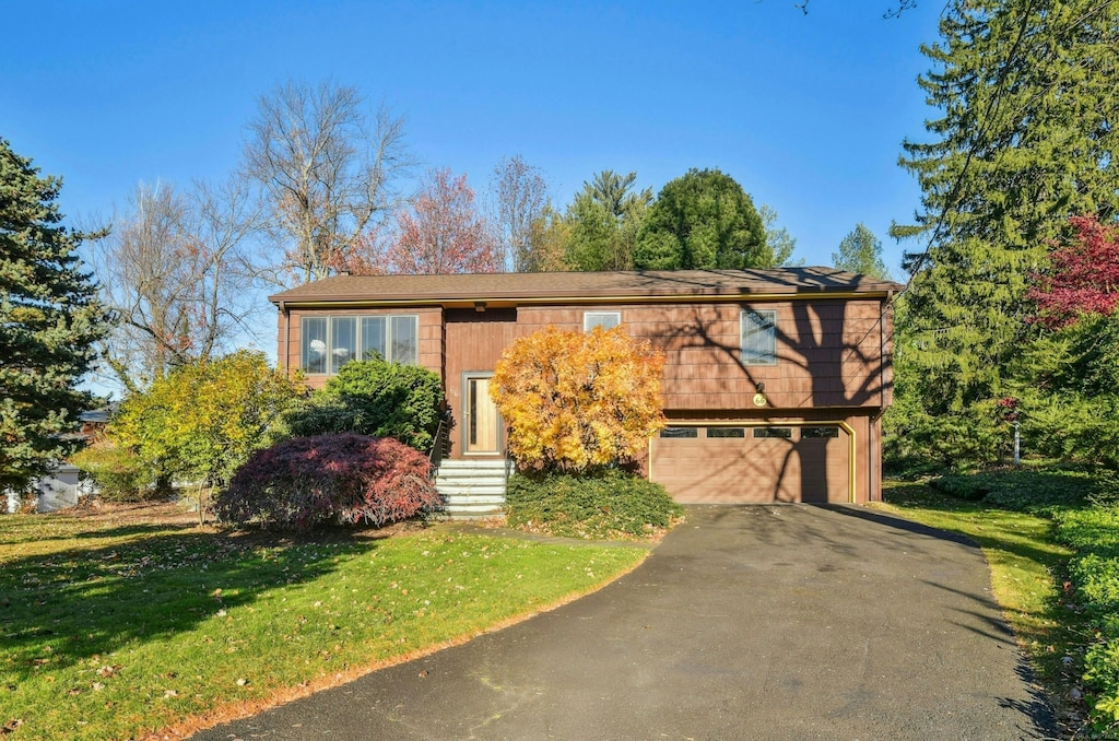 split foyer home with a garage and a front yard