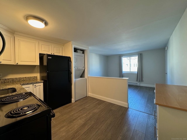 kitchen with a baseboard radiator, white cabinetry, stacked washer and clothes dryer, and black appliances