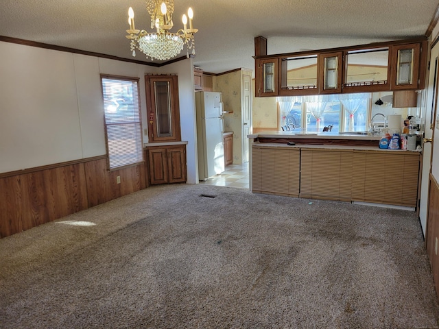 kitchen featuring light carpet, an inviting chandelier, a textured ceiling, white refrigerator, and pendant lighting