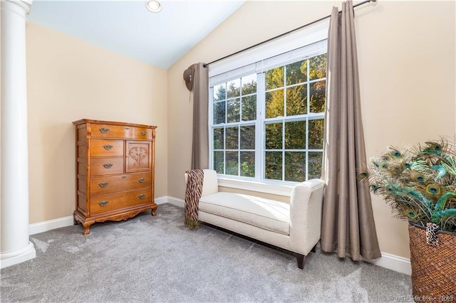 living area featuring decorative columns, carpet floors, and vaulted ceiling