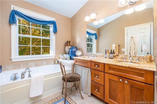 bathroom featuring lofted ceiling, vanity, a washtub, and a healthy amount of sunlight