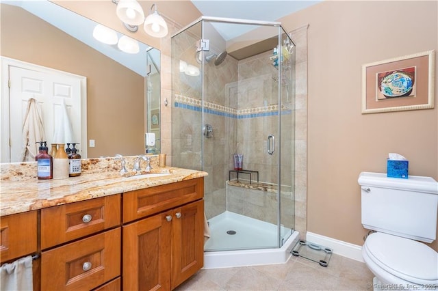 bathroom featuring toilet, tile patterned flooring, a shower with door, and vanity