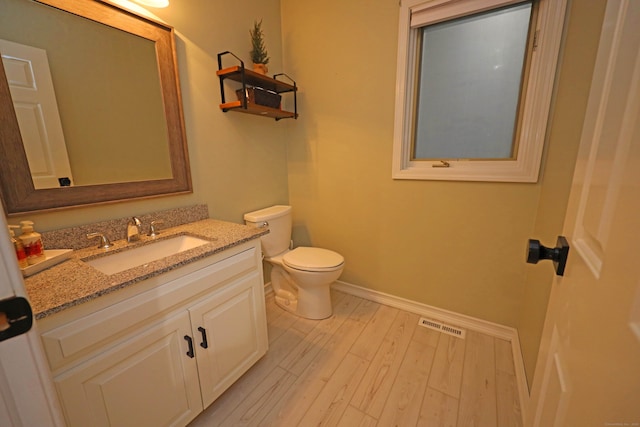 bathroom featuring hardwood / wood-style floors, toilet, and vanity