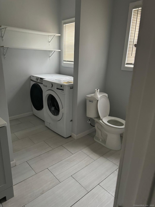 bathroom featuring independent washer and dryer and toilet