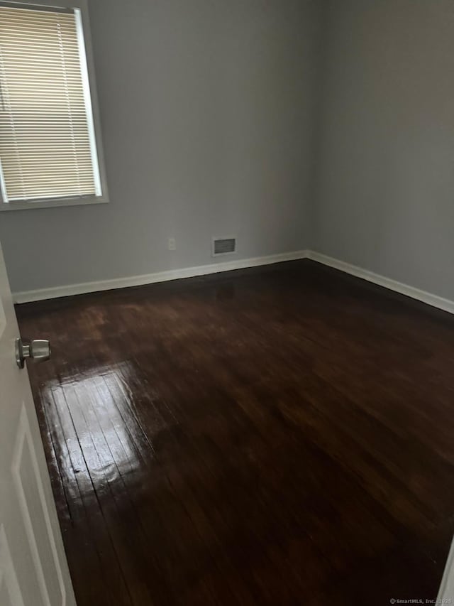 spare room featuring dark hardwood / wood-style flooring