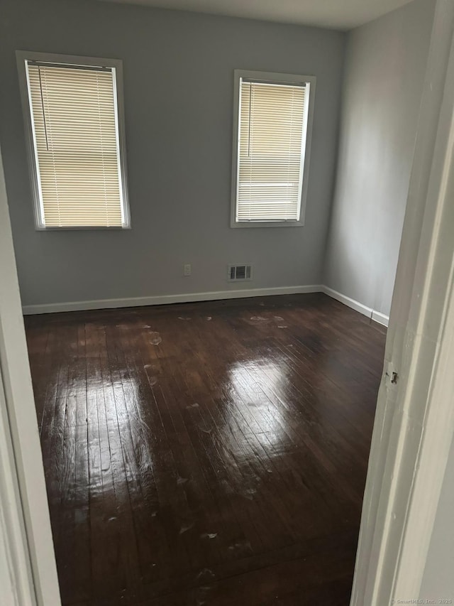 empty room with dark hardwood / wood-style flooring