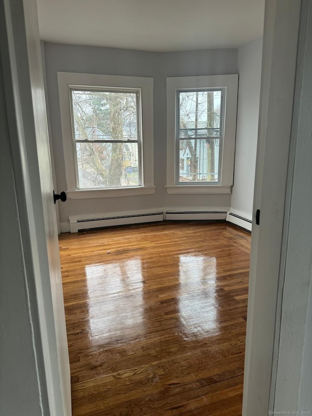 spare room featuring a baseboard radiator and light wood-type flooring