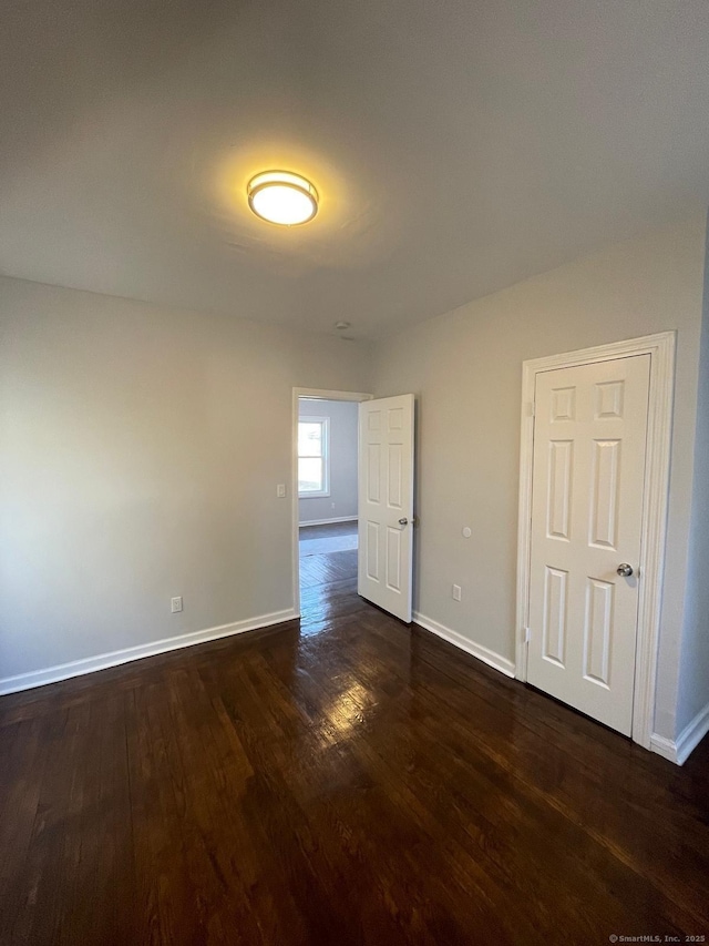 unfurnished room with dark hardwood / wood-style flooring