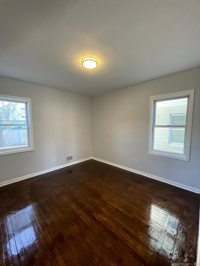 unfurnished room with dark hardwood / wood-style floors