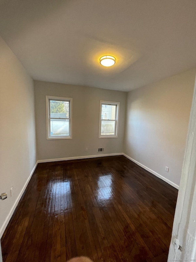 spare room with dark hardwood / wood-style floors