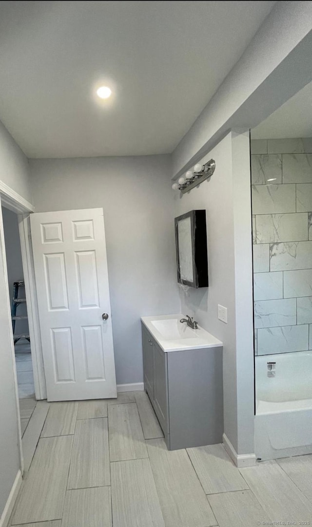 bathroom featuring tiled shower / bath combo and vanity