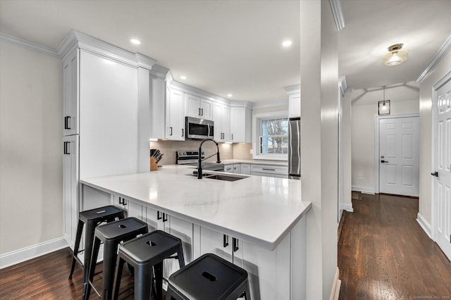 kitchen featuring a breakfast bar, kitchen peninsula, sink, and stainless steel appliances