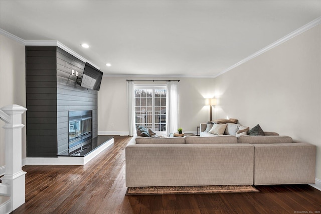 living room with dark hardwood / wood-style flooring, ornamental molding, and a fireplace