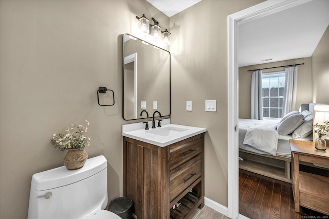 bathroom featuring toilet, vanity, and hardwood / wood-style flooring