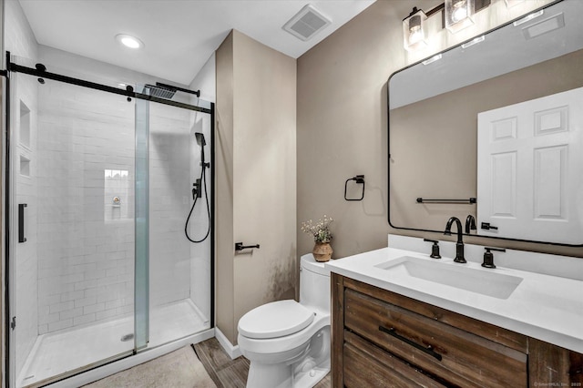 bathroom with toilet, vanity, and an enclosed shower