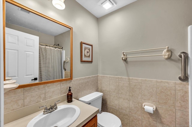 bathroom featuring tile walls, toilet, and vanity