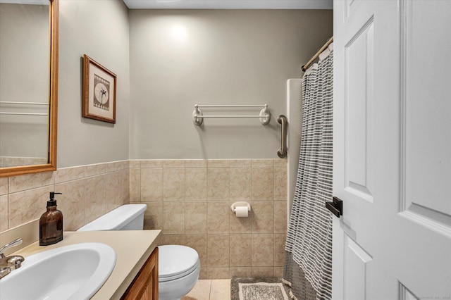 bathroom featuring toilet, tile walls, tile patterned floors, and vanity