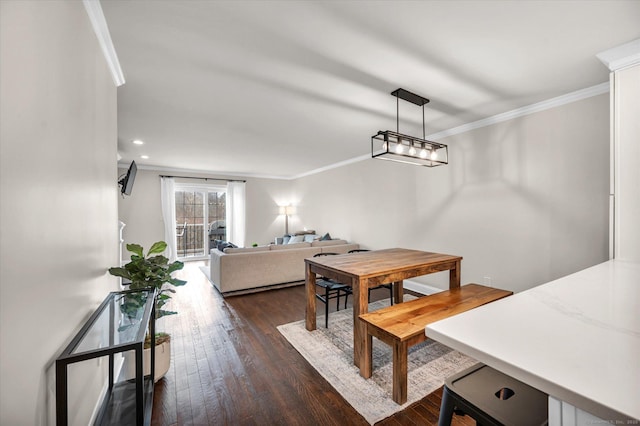 dining area with ornamental molding and dark hardwood / wood-style floors