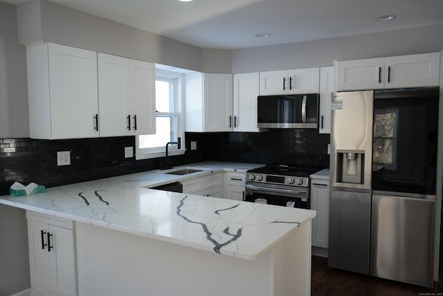 kitchen with sink, white cabinetry, light stone countertops, and stainless steel appliances