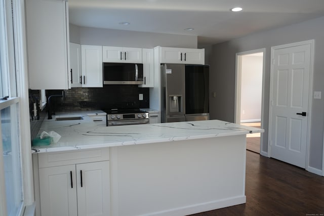 kitchen featuring sink, light stone counters, white cabinets, and appliances with stainless steel finishes