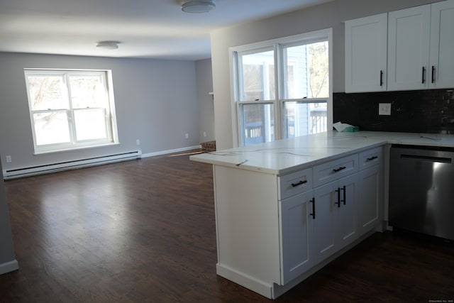 kitchen with kitchen peninsula, dishwasher, a baseboard heating unit, backsplash, and white cabinetry