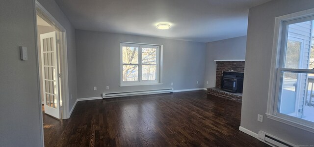 unfurnished living room featuring baseboard heating and dark wood-type flooring