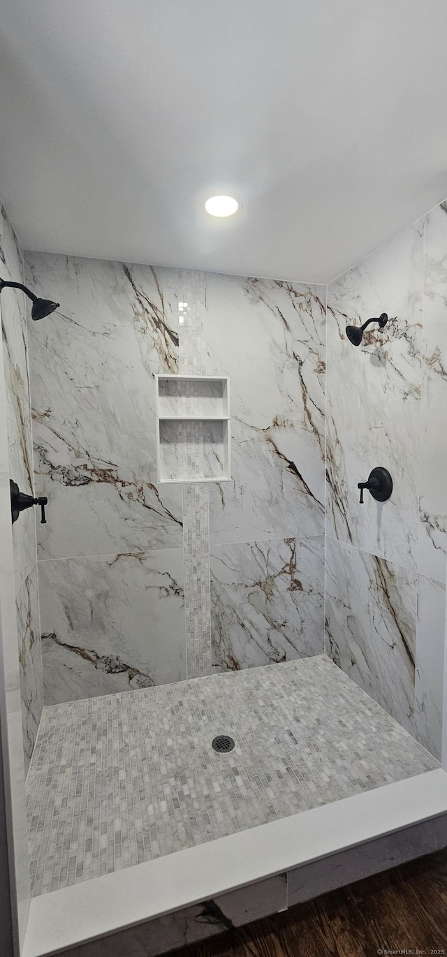 bathroom featuring tiled shower and hardwood / wood-style floors