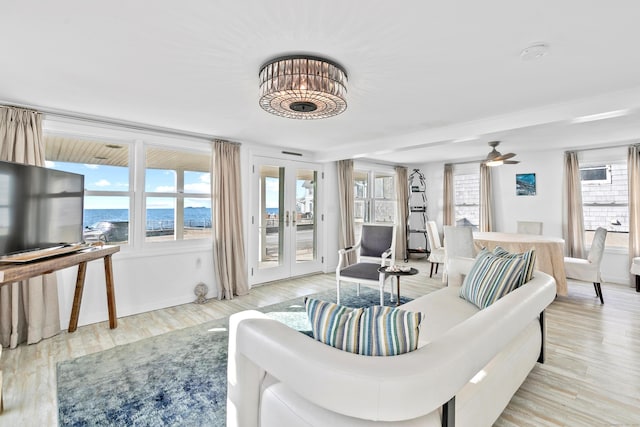 living room with ceiling fan, french doors, and light hardwood / wood-style floors